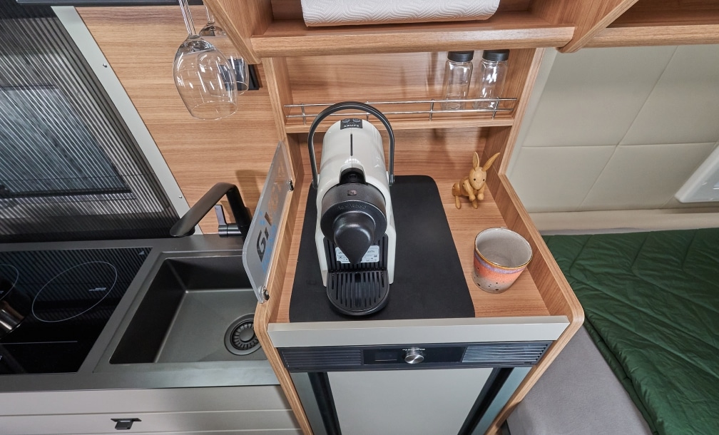 Kaffeemaschine neben Kochfeld und Spüle