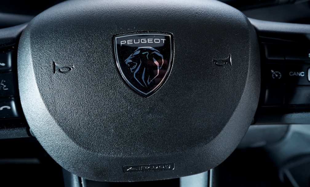 Nahaufnahme des Peugeot-Logos auf dem Lenkrad