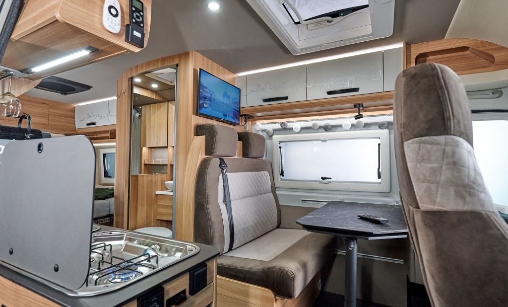 Blick über die Sitzgruppe zur Küchenzeile im VANTURA Campervan Der Freigeist