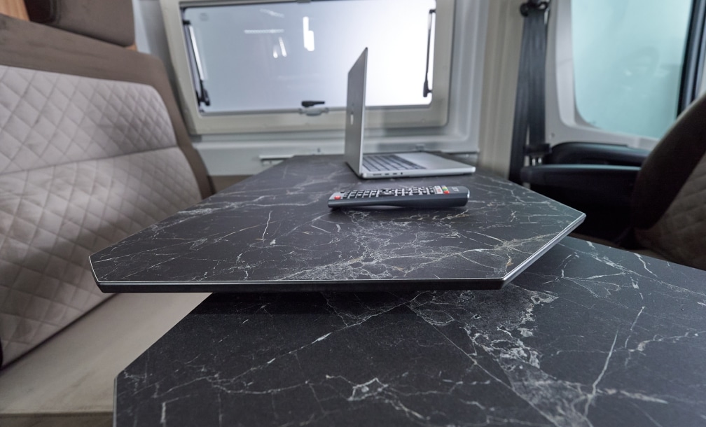 Laptop auf dem Marmortisch mit Blick durchs Seitenfenster