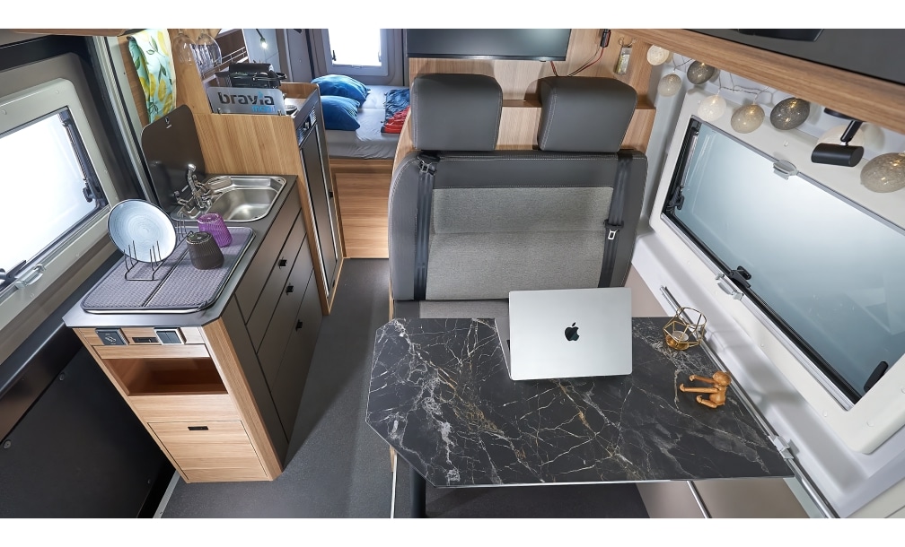 Ausklappbarer Tisch mit Marmoroptik als mobiler Arbeitsplatz im Camper