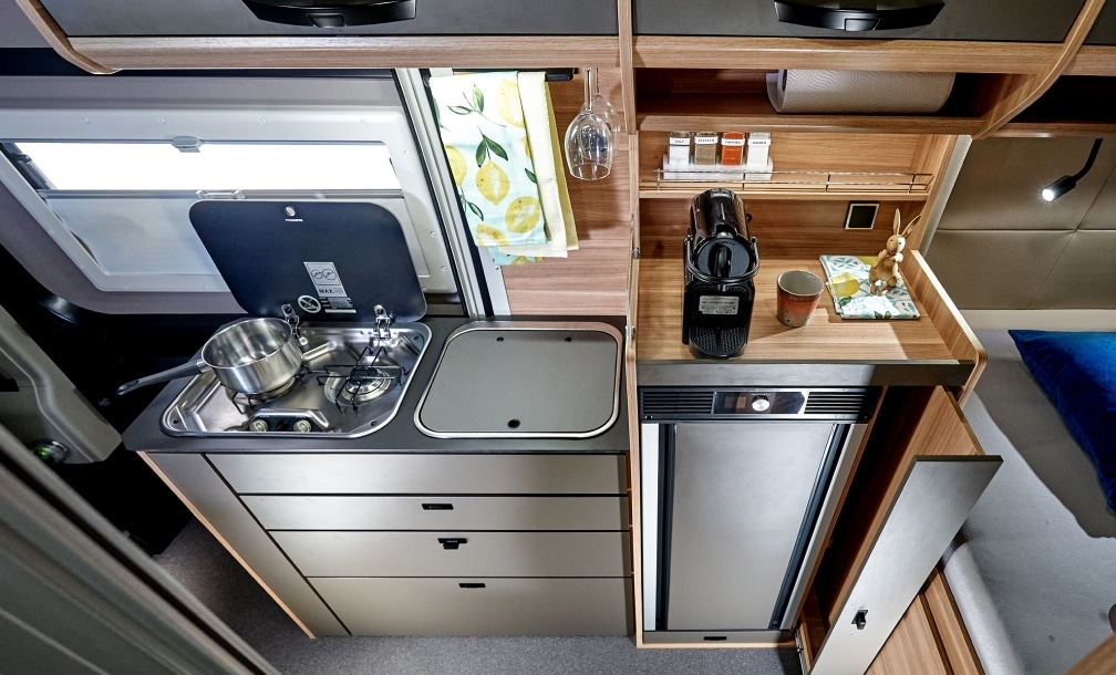 Küchenzeile mit Gas-Kochfeld, Spüle und Kompressorkühlschrank im Campervan