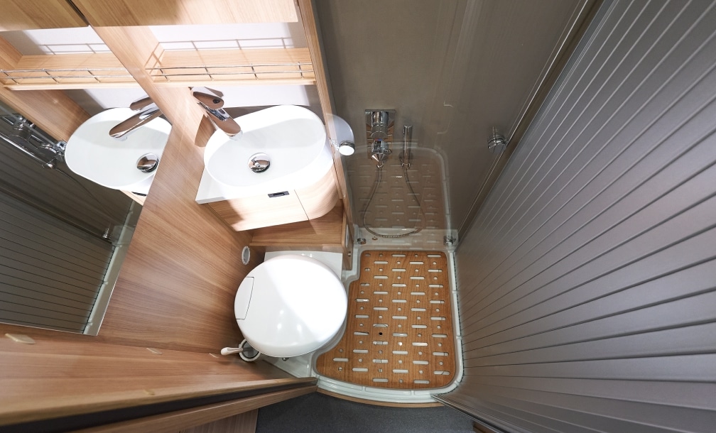Blick von oben auf Doppelwaschbecken, Dusche und Thetford Kassettentoilette im eigenen Bad