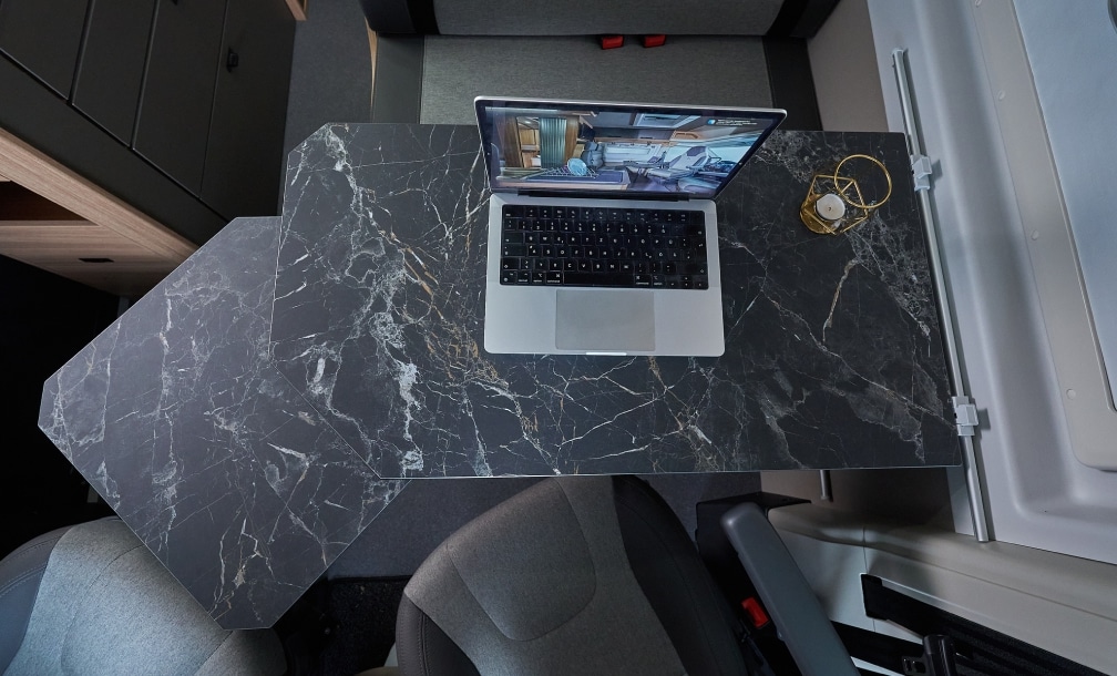 Laptop auf dem ausklappbaren Tisch – Homeoffice unterwegs im Campervan